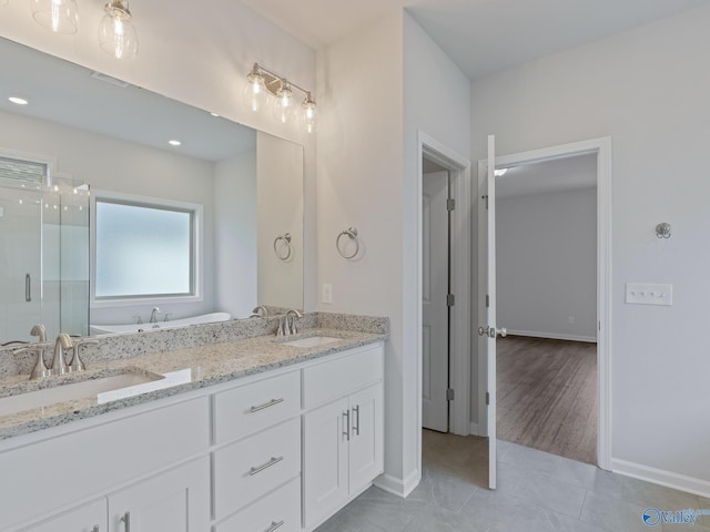 full bath featuring a shower stall, tile patterned floors, double vanity, and a sink