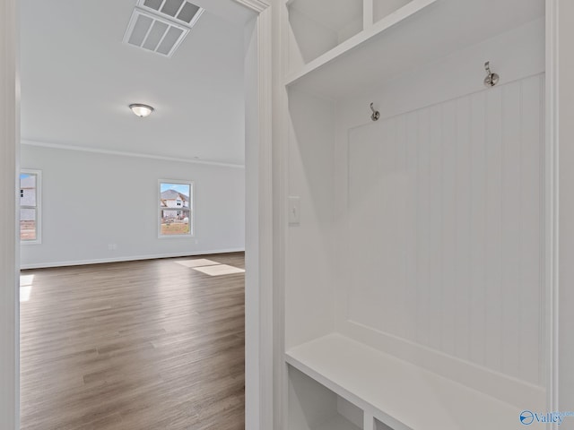 mudroom with wood finished floors, baseboards, and visible vents