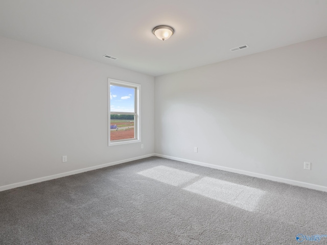 carpeted empty room featuring visible vents and baseboards