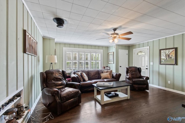 living room with baseboards, ceiling fan, and dark wood finished floors