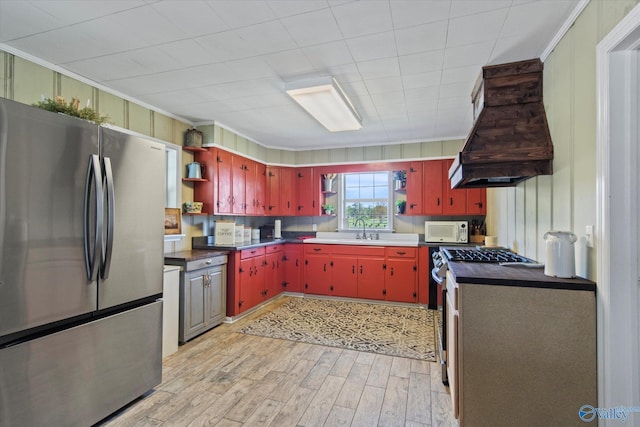 kitchen with a sink, open shelves, stainless steel appliances, custom range hood, and red cabinets