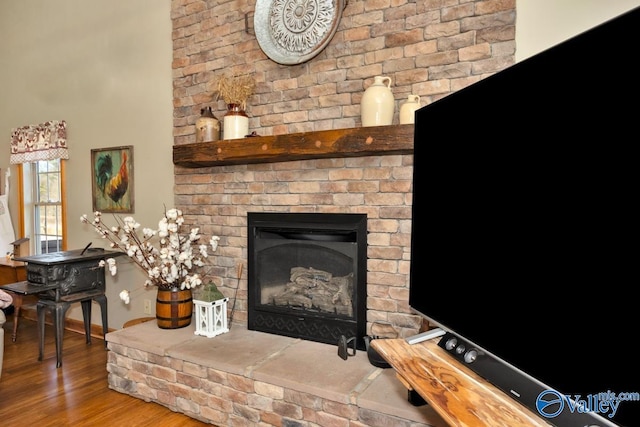 interior details featuring hardwood / wood-style flooring and a brick fireplace