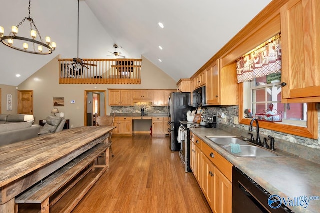 kitchen featuring sink, light hardwood / wood-style flooring, hanging light fixtures, tasteful backsplash, and black appliances