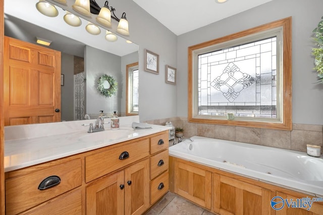 bathroom with tile patterned flooring, vanity, and a bath