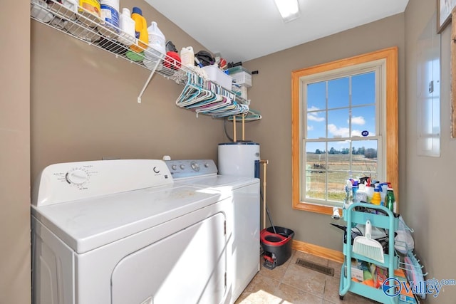 laundry room with light tile patterned flooring, washing machine and clothes dryer, and water heater