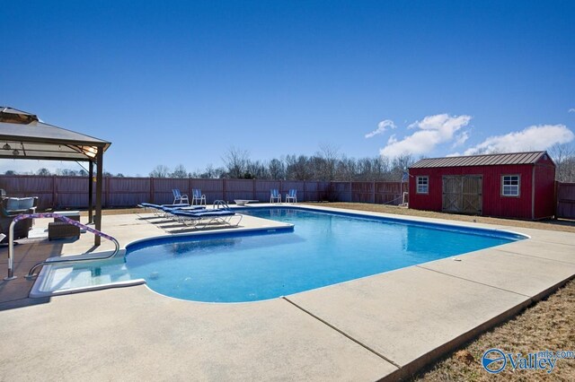 view of swimming pool featuring a gazebo, a patio area, and a storage shed