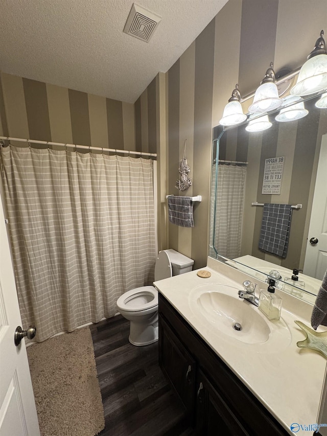 504 Sussex Dr SW, Huntsville, AL 35824 - full bath with wallpapered walls, wood finished floors, toilet, vanity, and a textured ceiling