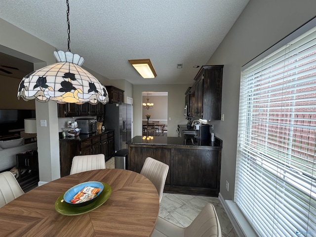 504 Sussex Dr SW, Huntsville, AL 35824 - dining area with a textured ceiling, a chandelier, baseboards, and light marble finish flooring