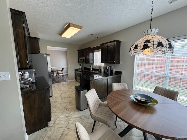 504 Sussex Dr SW, Huntsville, AL 35824 - dining area featuring a textured ceiling, plenty of natural light, and light tile patterned floors