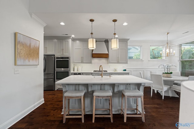 kitchen with premium range hood, appliances with stainless steel finishes, hanging light fixtures, and dark wood-type flooring