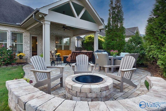 view of patio featuring ceiling fan and an outdoor living space with a fire pit