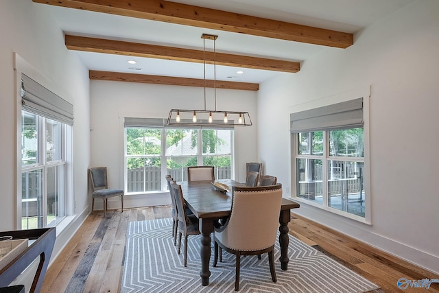 dining space with beamed ceiling and hardwood / wood-style floors