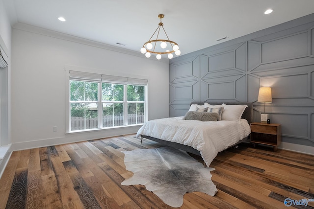 bedroom featuring dark hardwood / wood-style flooring, a chandelier, and ornamental molding