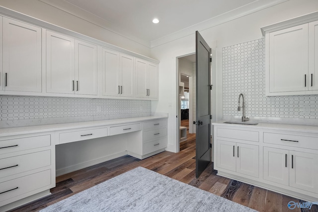 office featuring ornamental molding, sink, dark hardwood / wood-style floors, and built in desk