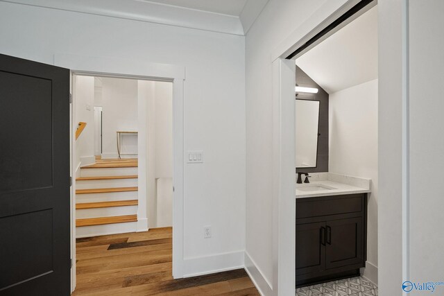 bathroom with vaulted ceiling, hardwood / wood-style floors, and vanity