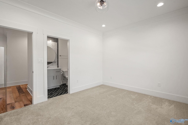 unfurnished bedroom featuring carpet floors and ensuite bathroom