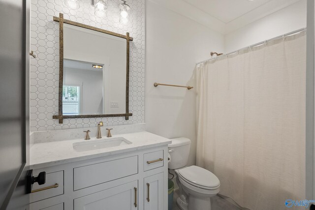 bathroom with vanity, crown molding, and toilet