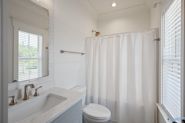 bathroom featuring vanity, backsplash, and toilet