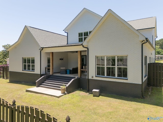 rear view of property featuring a lawn