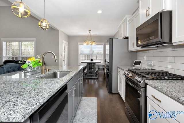 kitchen with sink, black dishwasher, stainless steel gas range oven, light stone countertops, and white cabinets