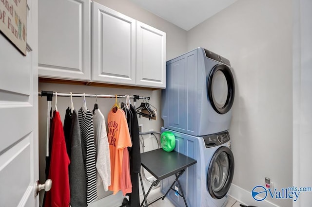 washroom with cabinets and stacked washer and clothes dryer