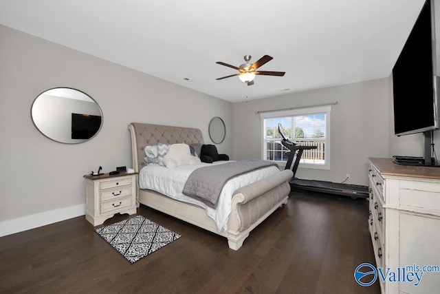 bedroom with a baseboard heating unit, dark wood-type flooring, and ceiling fan