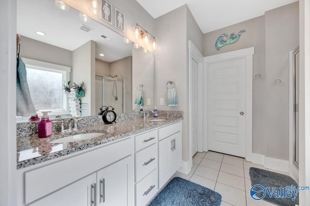 bathroom featuring tile patterned flooring, vanity, and a shower with shower door