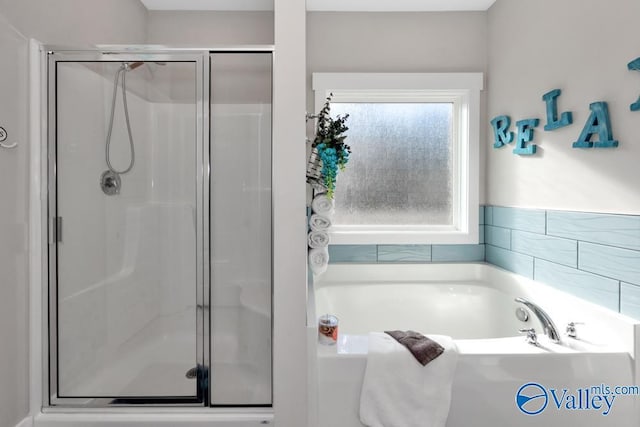 bathroom featuring separate shower and tub