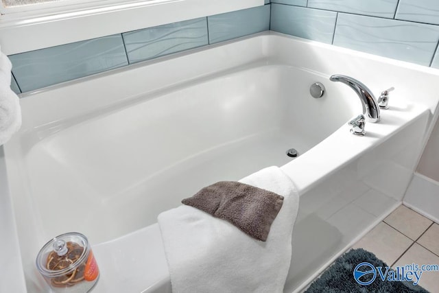 bathroom with tile patterned flooring and a washtub