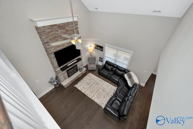 living room featuring ceiling fan, a fireplace, and dark hardwood / wood-style flooring