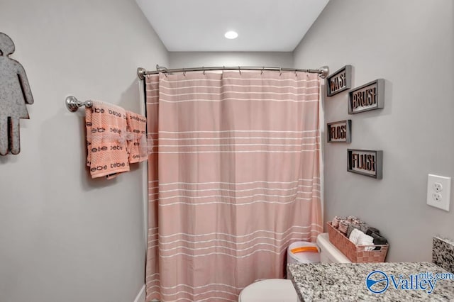 bathroom featuring walk in shower, vanity, and toilet