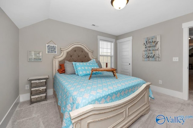 bedroom with lofted ceiling and light colored carpet