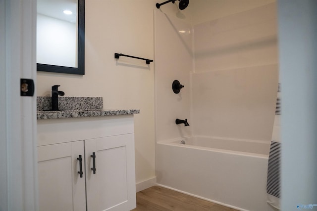 bathroom with hardwood / wood-style flooring, vanity, and shower / bathing tub combination
