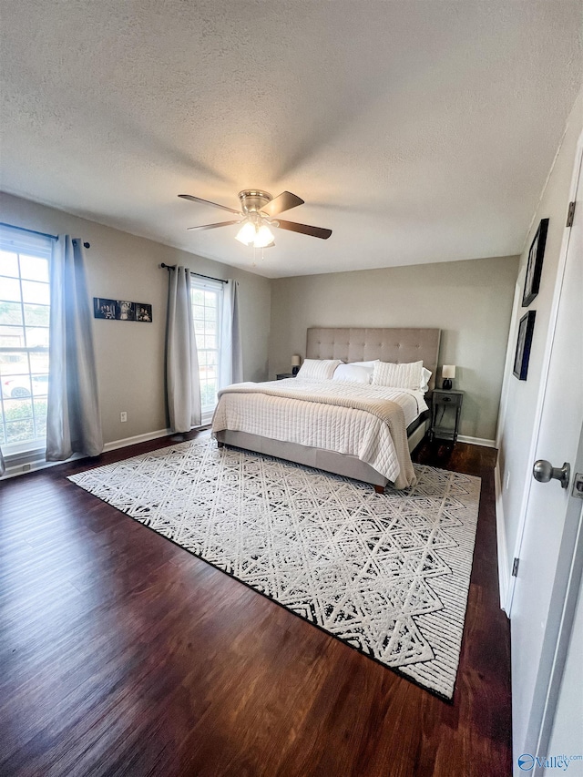 bedroom with hardwood / wood-style floors, a textured ceiling, and ceiling fan