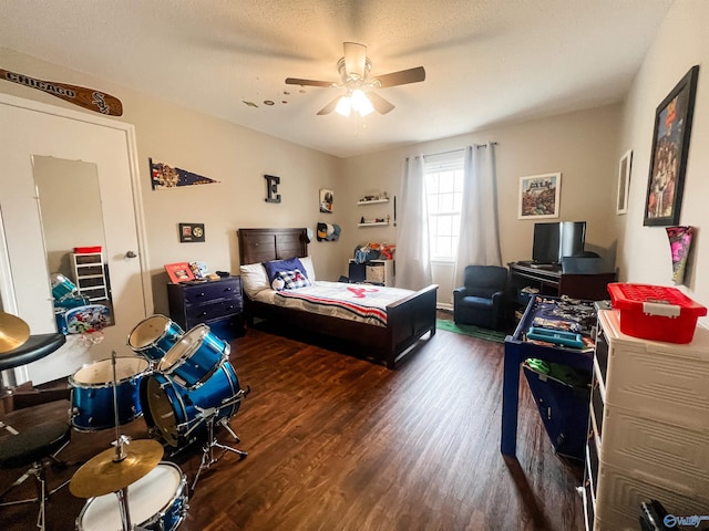 bedroom with ceiling fan, dark hardwood / wood-style flooring, and a textured ceiling