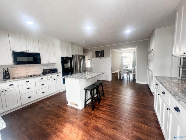 kitchen featuring white cabinetry, a kitchen island, and black appliances