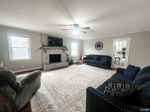 living room featuring a fireplace, hardwood / wood-style flooring, ceiling fan, crown molding, and a textured ceiling