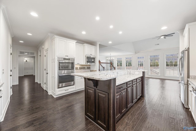 kitchen featuring white cabinetry, stainless steel appliances, a kitchen island, and dark brown cabinets