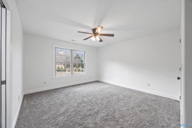 carpeted spare room featuring ceiling fan