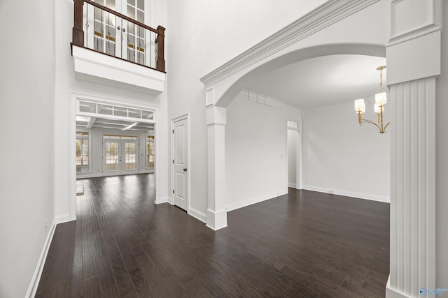 hall featuring dark hardwood / wood-style flooring, ornamental molding, french doors, and a chandelier