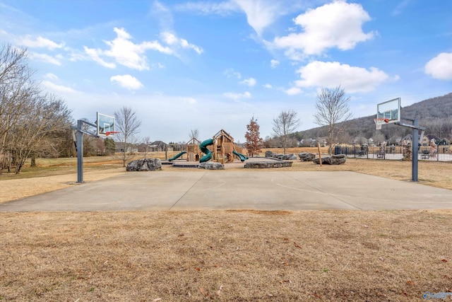 view of sport court with a lawn and a playground