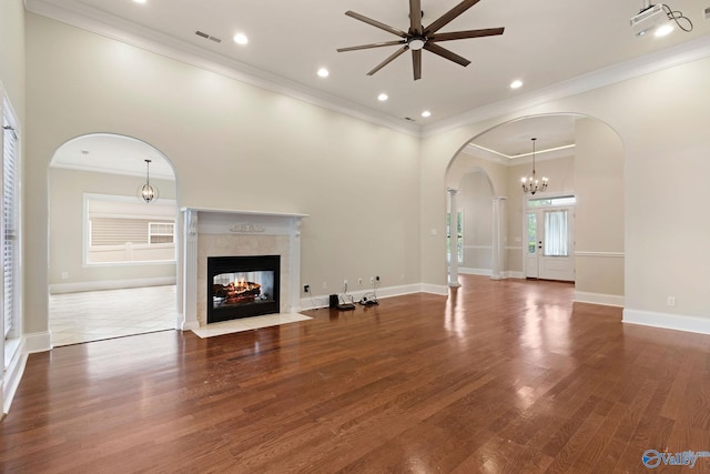 505 Barkley St SW, Hartselle, AL 35640 - unfurnished living room with a ceiling fan, arched walkways, a tile fireplace, a chandelier, and wood finished floors