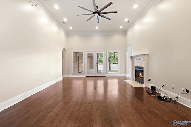 505 Barkley St SW, Hartselle, AL 35640 - unfurnished living room featuring arched walkways, crown molding, a tiled fireplace, ceiling fan, and baseboards