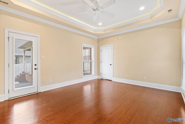 505 Barkley St SW, Hartselle, AL 35640 - empty room featuring a tray ceiling, dark wood finished floors, ceiling fan, crown molding, and baseboards