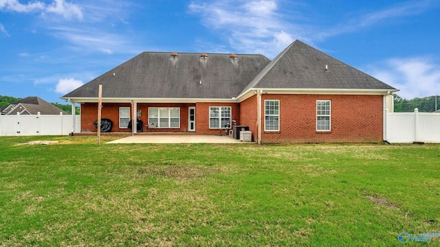 back of property with brick siding, a yard, a fenced backyard, and a patio area