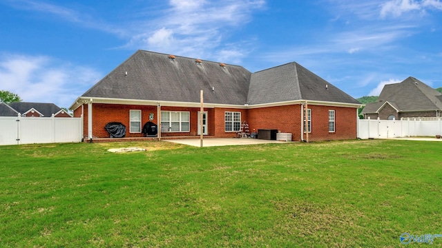 back of property featuring a lawn, brick siding, and a patio area
