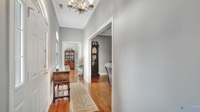 entrance foyer with baseboards, visible vents, an inviting chandelier, and light wood-style flooring