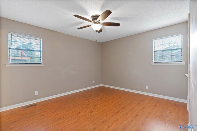 unfurnished bedroom featuring light wood-type flooring, ceiling fan, and a textured ceiling