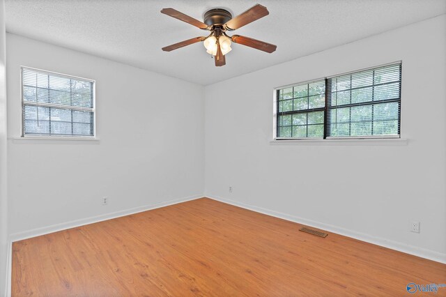 empty room with ceiling fan and hardwood / wood-style flooring