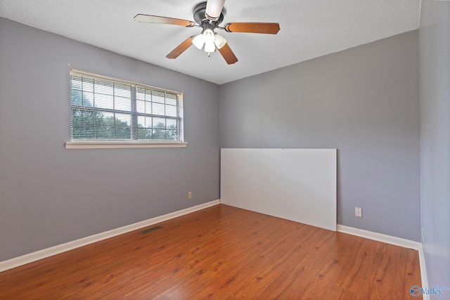 spare room with ceiling fan, hardwood / wood-style flooring, and a textured ceiling